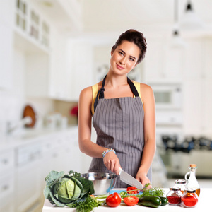 年轻的女人在厨房里做饭。健康食品蔬菜沙拉。饮食。节食的概念。健康的生活方式。在家里做饭