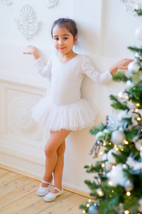 站在圣诞树旁的年轻的芭蕾舞演员