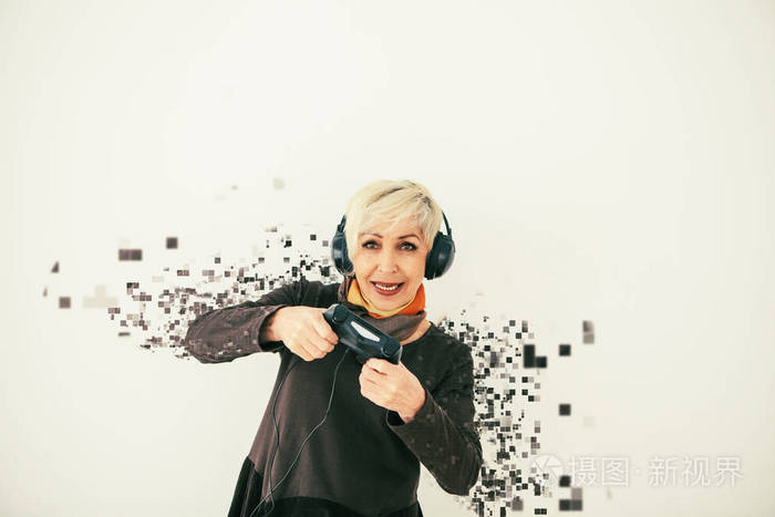一位年长的妇女玩视频游戏, 被分割成像素。具有视觉效果的概念性照片, 意味着老年人和新技术