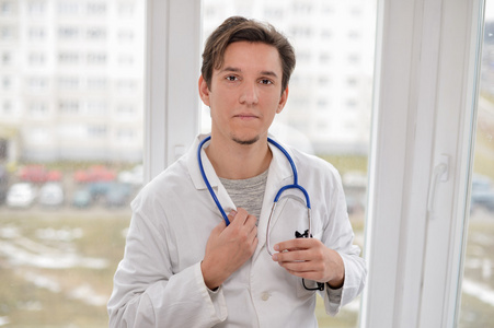 年轻的男医生，站在窗口附近