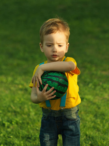 可爱的积极孩子，绿色的草地上的球玩得很开心