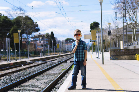 春天在火车站等待火车的男孩
