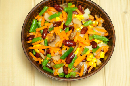 在木桌上的粘土盘子里的蔬菜.