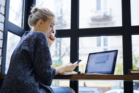 迷人的金发女学生聊天在社交网络中, 同时使用 wifi 连接在咖啡馆创建