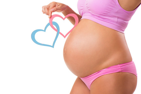 粉色和蓝色的心是孕妇肚子里的特写镜头。猜猜宝宝孩子的性别 女孩 男孩或双胞胎