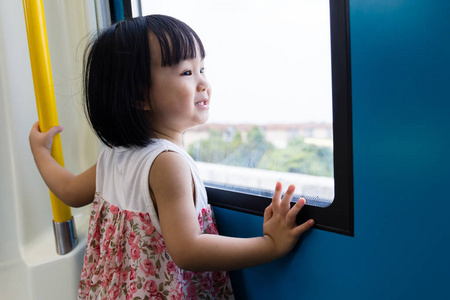 亚洲的中国小女孩里面看在窗户旁边的火车