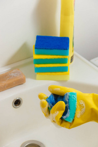 用黄色橡胶手套清洗浴室用蓝色海绵家务, 春季清洁概念