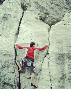 宽阔的山谷的背景与石灰石墙上爬的岩石 Climber.Young 人