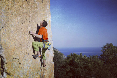 宽阔的山谷的背景与石灰石墙上爬的岩石 Climber.Young 人