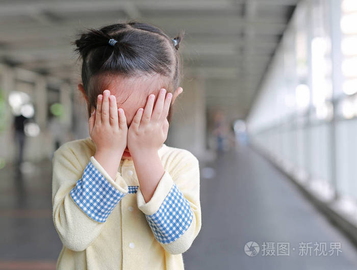 亚洲小女孩用手捂住脸