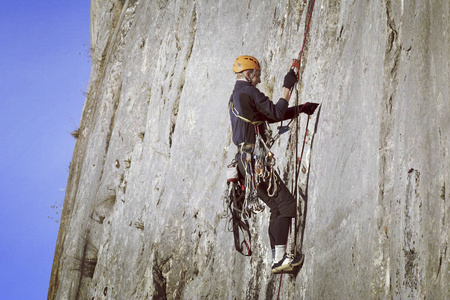 宽阔的山谷的背景与石灰石墙上爬的岩石 Climber.Young 人