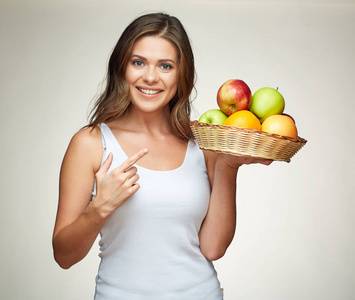 微笑着拿着柳条篮子水果的白色单重态的女人