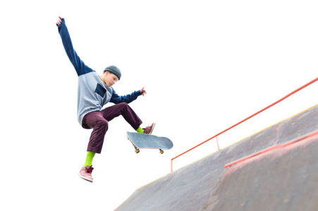 溜冰坡道少年滑板在盖帽做一个把戏与跳跃在舷梯在 skatepark.