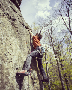 宽阔的山谷的背景与石灰石墙上爬的岩石 Climber.Young 人