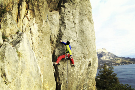 宽阔的山谷的背景与石灰石墙上爬的岩石 Climber.Young 人