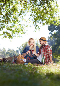 美丽的年轻夫妇在乡下野餐。幸福的家庭