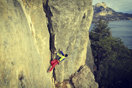 宽阔的山谷的背景与石灰石墙上爬的岩石 Climber.Young 人