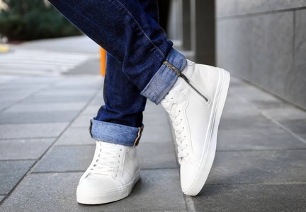 时髦的人在白色鞋子在城市街道