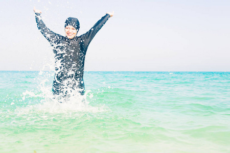 年轻女子在泼水的 Burkini