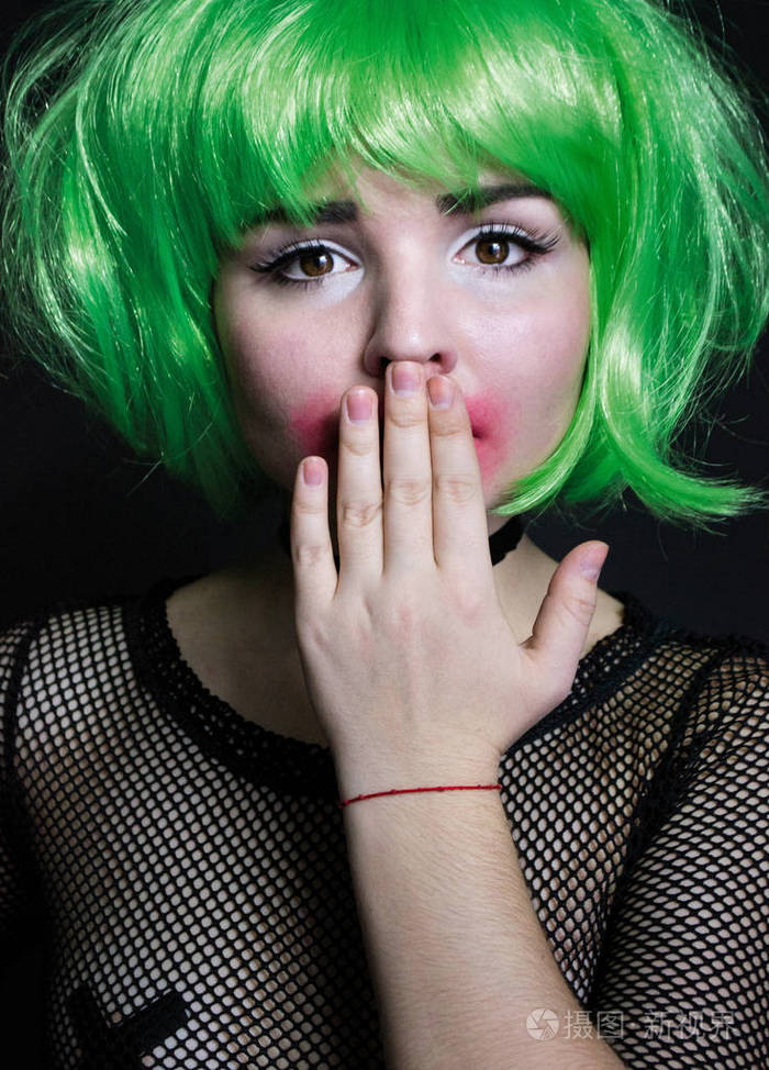 一个女孩穿着绿色的头发与网格的肖像触动他的嘴