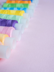彩色缝纫按钮和粉红色背景线