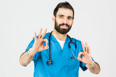 穿着蓝色制服的医生的肖像, 他竖起大拇指。孤立