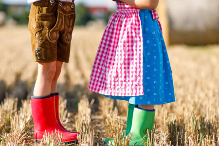 两个孩子在传统的巴伐利亚服装和红色和绿色橡胶