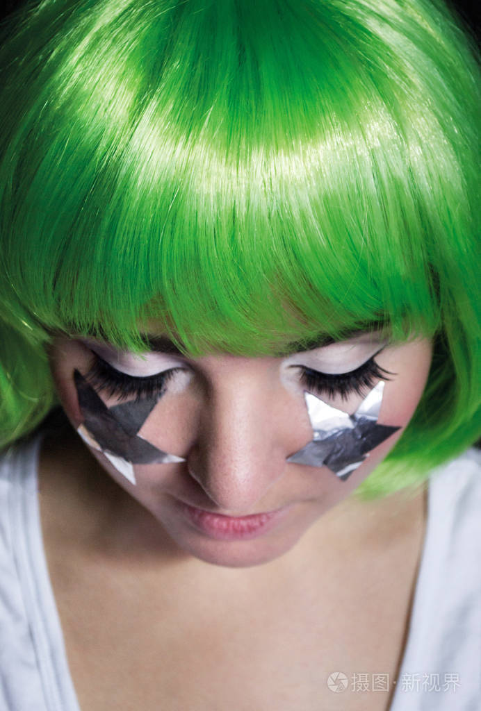 一个女孩与绿色的头发和她的两颊眼睛明星肖像关闭