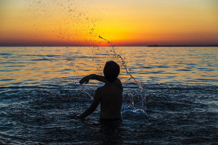 在西西里日落时分在海边沐浴的少年男孩