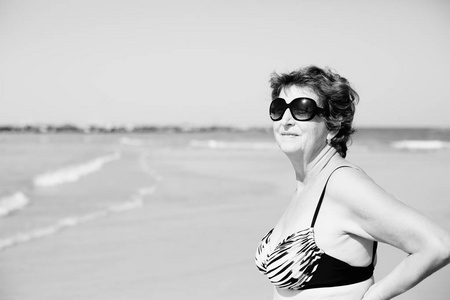高级的女人站在沙滩上