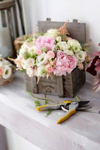 花店里的桌子上装饰着玫瑰花束。美丽的玫瑰花束安排在一个老式木箱中的特殊事件