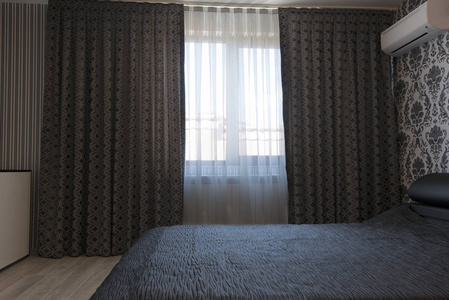 长窗帘和窗纱的窗户年轻漂亮的女人在房间里挂窗帘封闭的美丽的灰色