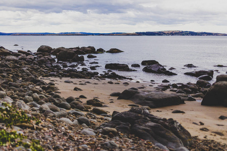 荒凉的海滩在霍巴特, 塔斯马尼亚与岩石在前景照片