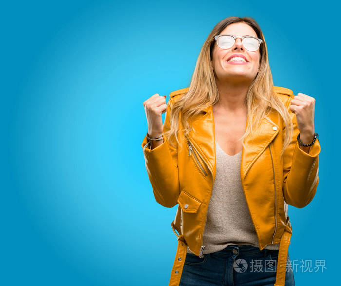 美丽的年轻女子高兴和兴奋的庆祝胜利表达了巨大的成功, 权力, 能量和