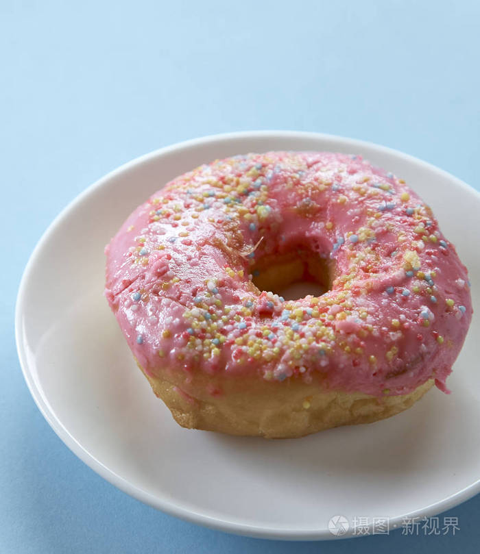 蓝色背景上的一个粉红色甜甜圈