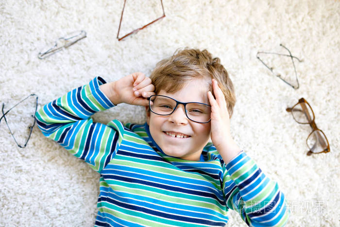 金发碧眼的孩子长着棕色眼镜小男孩的特写肖像照片