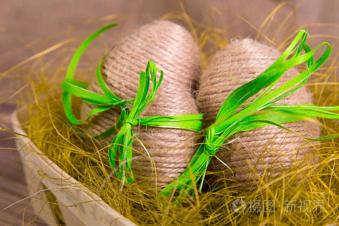 复活节彩蛋裹缠上木麻布木背景的黄巢。乡村风格