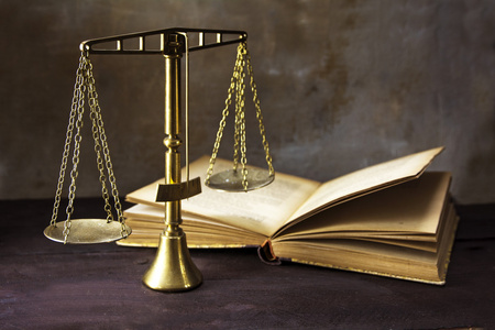 正义和一本旧书上棕色的早饭中规中矩的老式黄铜天平照片