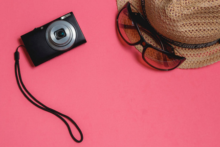 旅行配件 太阳镜, 照片照相机, 棕色帽子, 粉红色背景。Copyspace 旅游概念