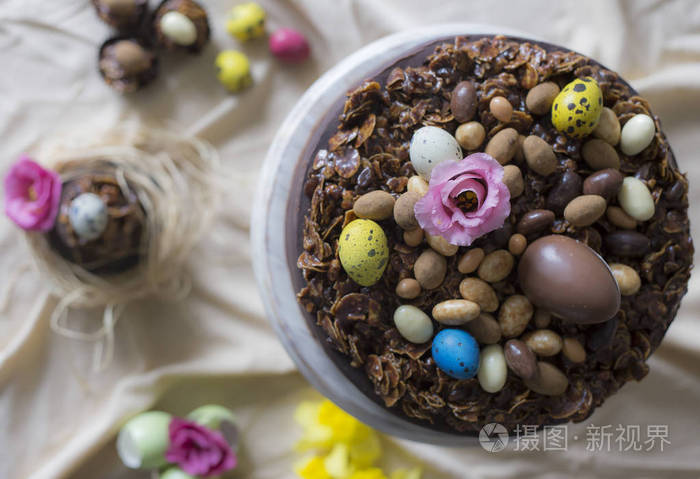 带花的复活节巧克力蛋糕。节日餐桌装饰用复活节蛋糕, 鲜花和五颜六色的鸡蛋