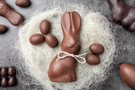 巧克力复活节兔子和鸡蛋的巢在乡村背景