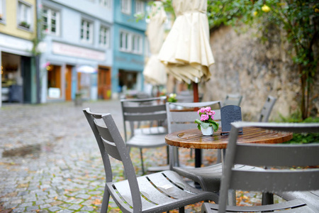 户外咖啡厅带粉红色鲜花花束的椅子和桌子