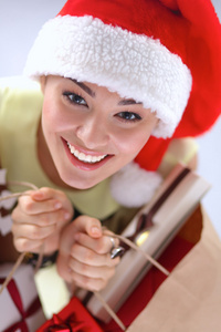 礼品盒红色背景上圣诞老人的帽子上快乐的女孩