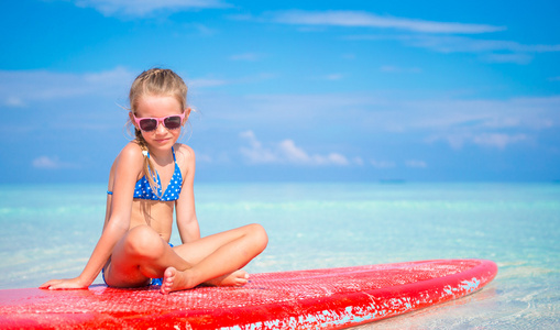 在绿松石海冲浪板上的小可爱女孩