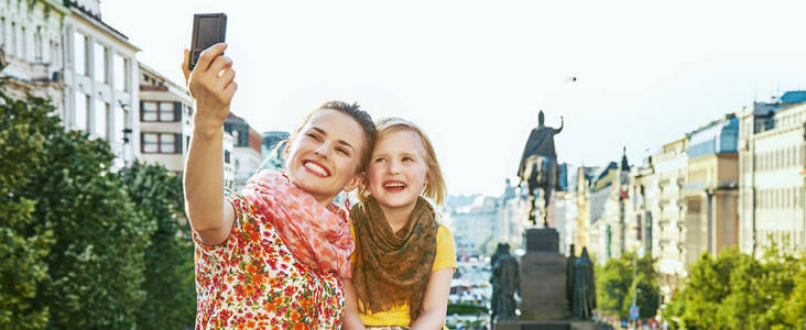 母亲和女儿与数码摄像头拍到正在自拍照在布拉格