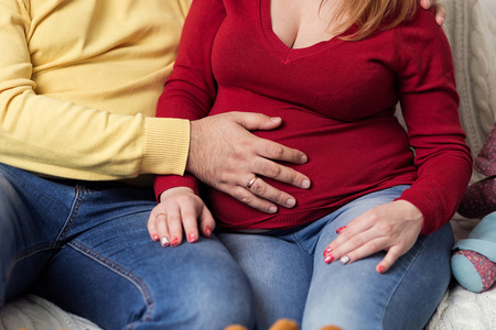 孕妇腹部的照片。手抱着孕妇的肚子。关闭人类的手拿着孕妇的肚子。怀孕的妇女抱着她的肚子。怀孕。怀孕的概念