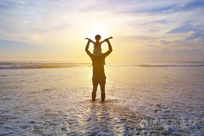 剪影父亲骑着脖子背着女儿看着大海.全家享受假期