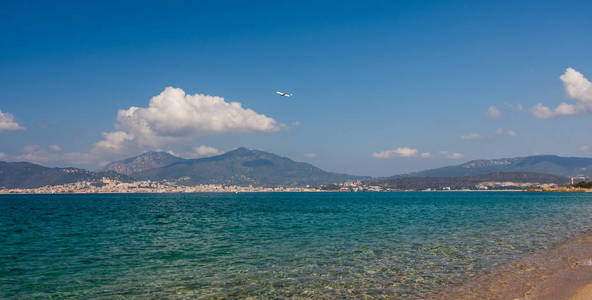 飞机在科西嘉海滩上空飞行。阿雅克肖城的背景, 与科西嘉山脉