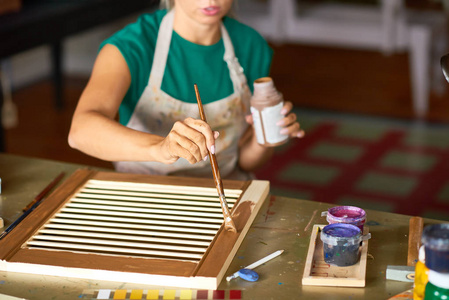 在艺术工作室里欣赏工作的年轻女子油漆百叶窗与青铜漆, 使 Diy 室内装饰