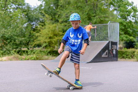快乐的男孩练习滑板上的平衡